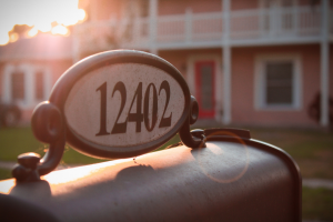 A mailbox outside of a house with the home address on top of it