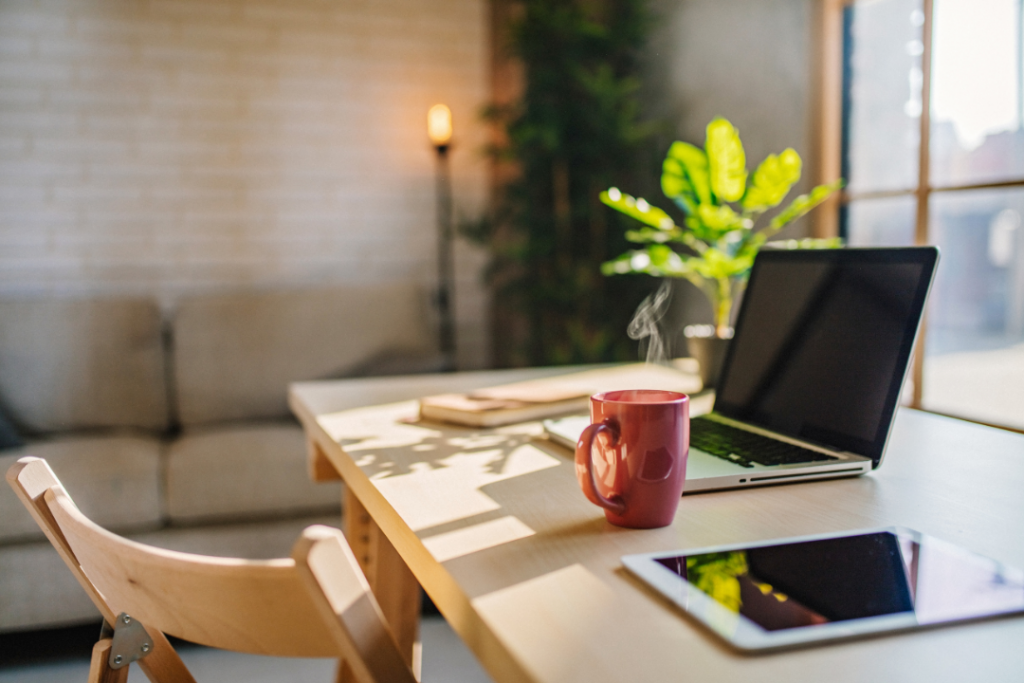 Home office with a laptop, mug, and tablet on the desk