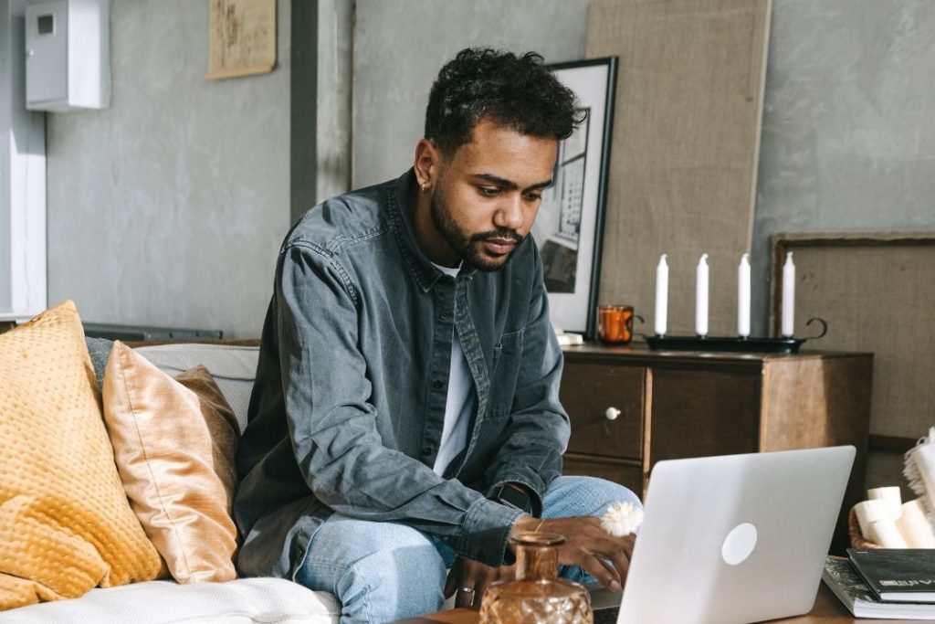 Man seated on a Couch working on a Laptop