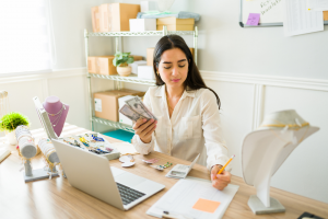 Jewelry entrepreneur counting money in her home office