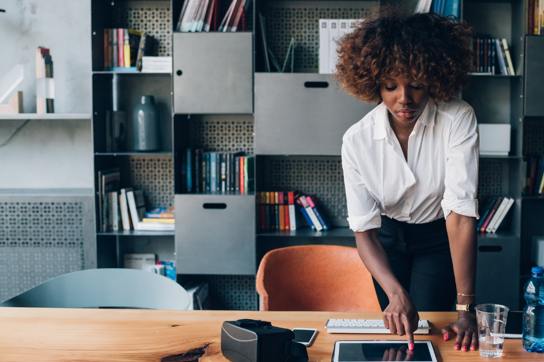 A black woman on her tablet in her home office