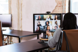 A person having a conference call on the computer in their home office