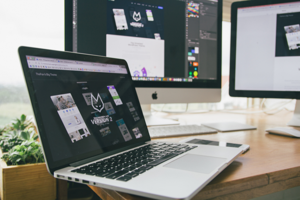 laptop with two computers displaying website mock up designs